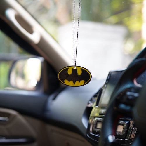 Batmobile logo car air freshener hanging from a car's rearview mirror.