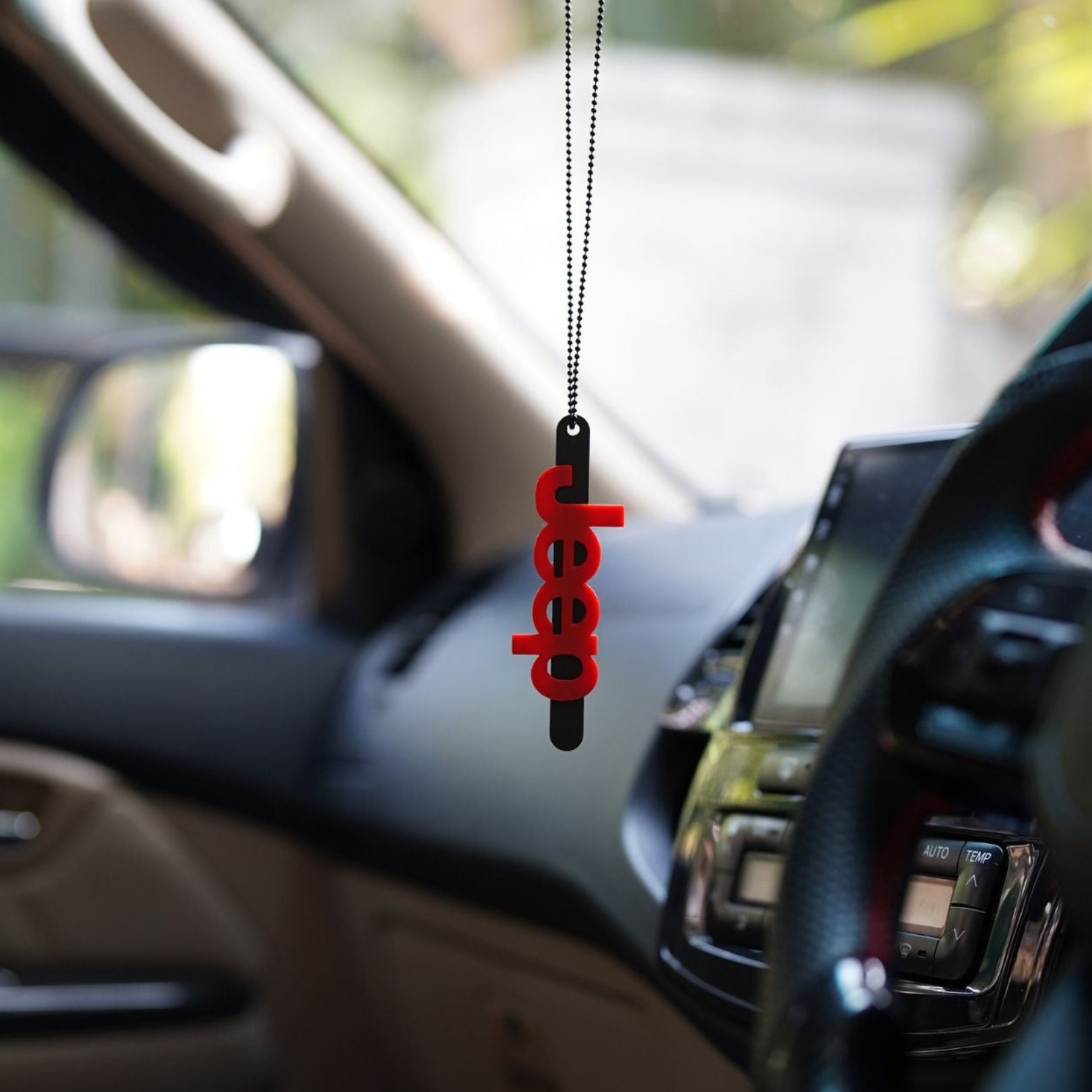 Car interior with a red 'deep' pendant hanging from the rearview mirror.
